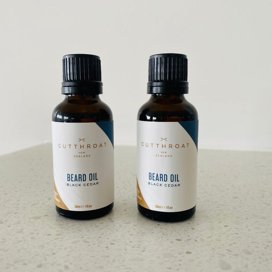 Handmade Black Cedar Beard Oil in a recyclable amber glass bottle with black dripolator cap, featuring natural ingredients like Jojoba and Grape Seed oils, and a cedarwood and patchouli fragrance.