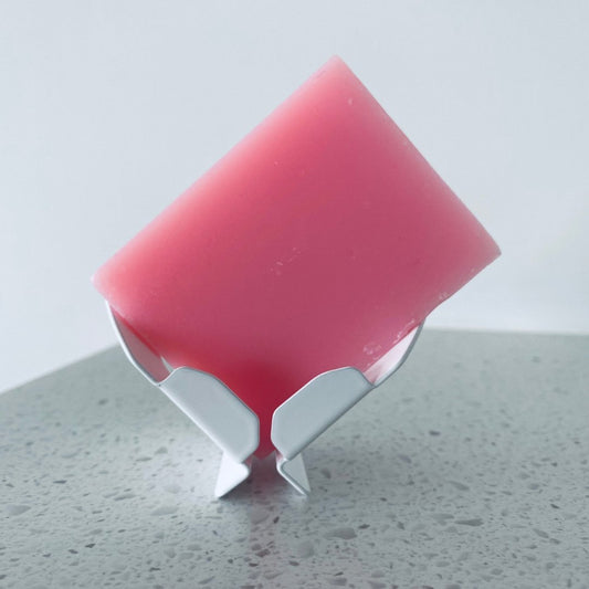 Block Dock™ vertical soap dish holding a bar of soap upright, designed for smooth surfaces like glass.