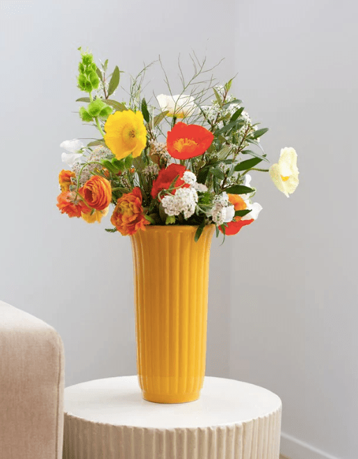 Eden Vases in tall, slim designs. Crafted from ceramic stoneware with thin ribs and glazed mustard for a classic, elegant finish.