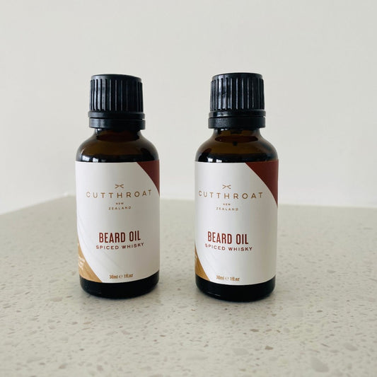 Spiced Whisky Beard Oil in a recyclable amber glass bottle with black dripolator cap, featuring natural ingredients like Jojoba and Grape Seed oils, with warm fragrance notes of whiskey, bay rum, and tobacco.